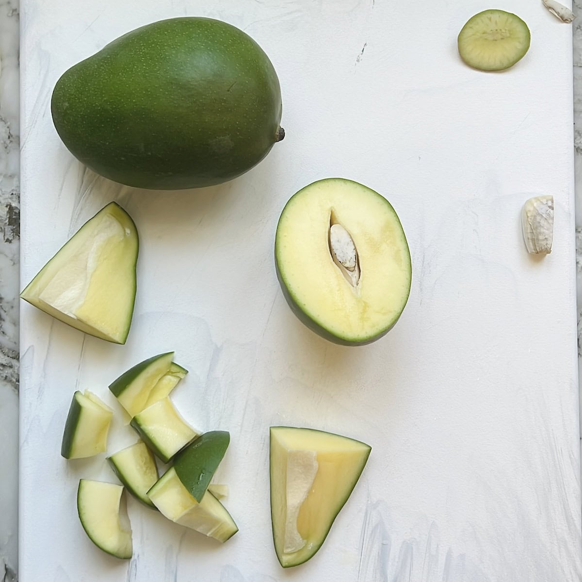 raw mango cut in half and quarters 