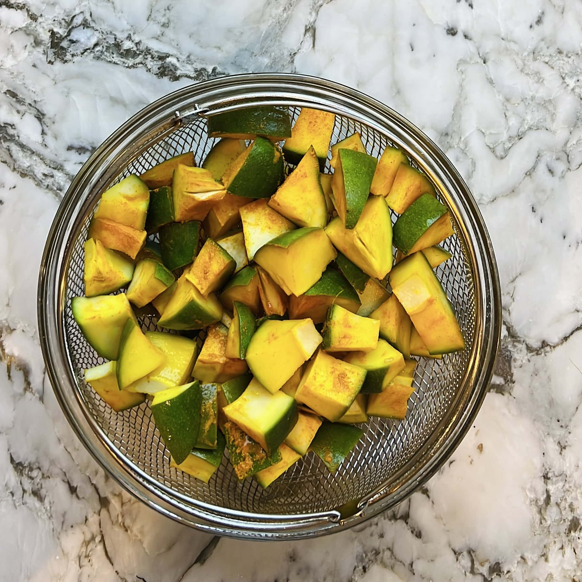 draining out excess moisture from raw mango pieces 