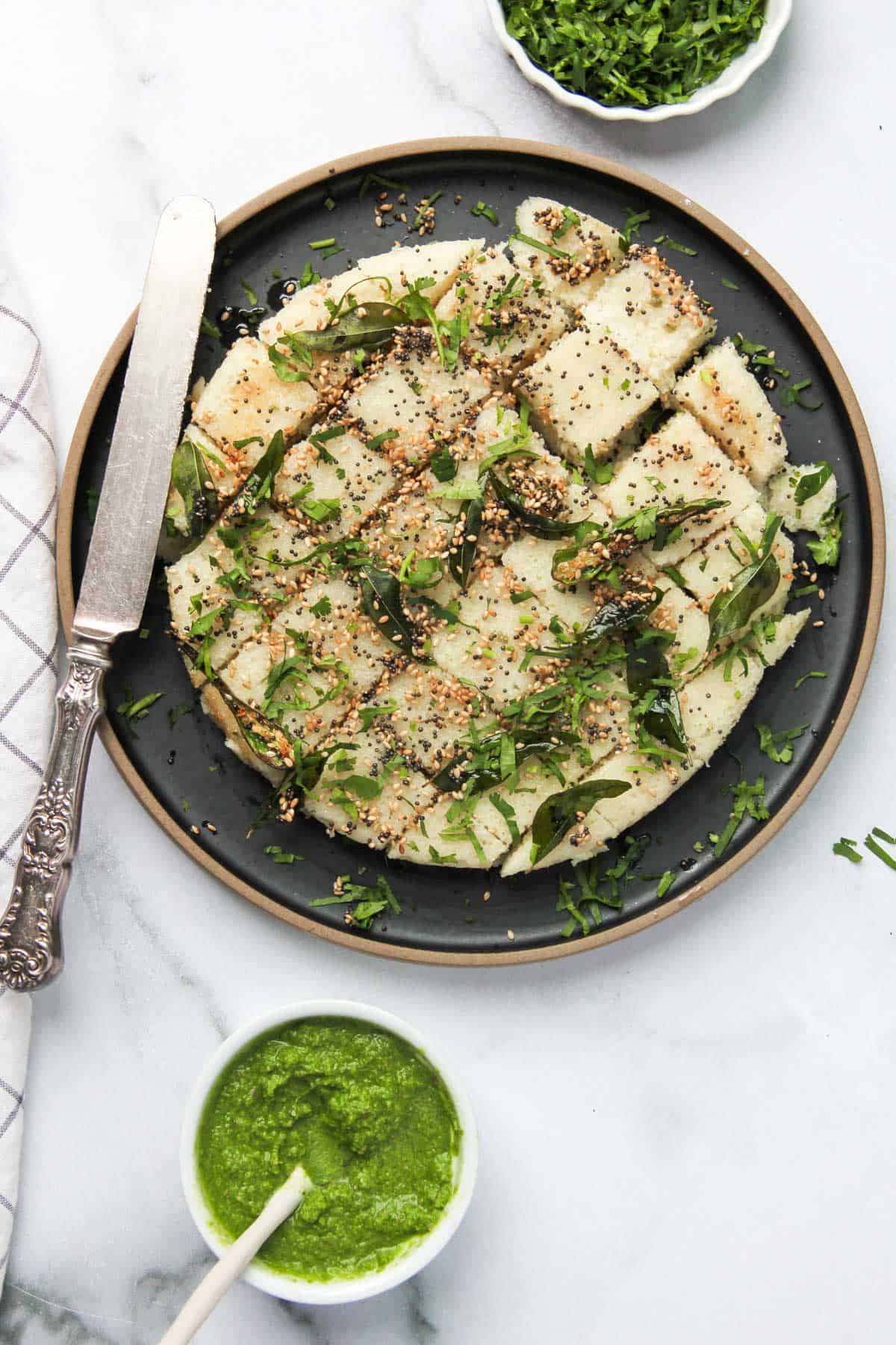 rava dhokla garnished with sesame seeds and cilantro