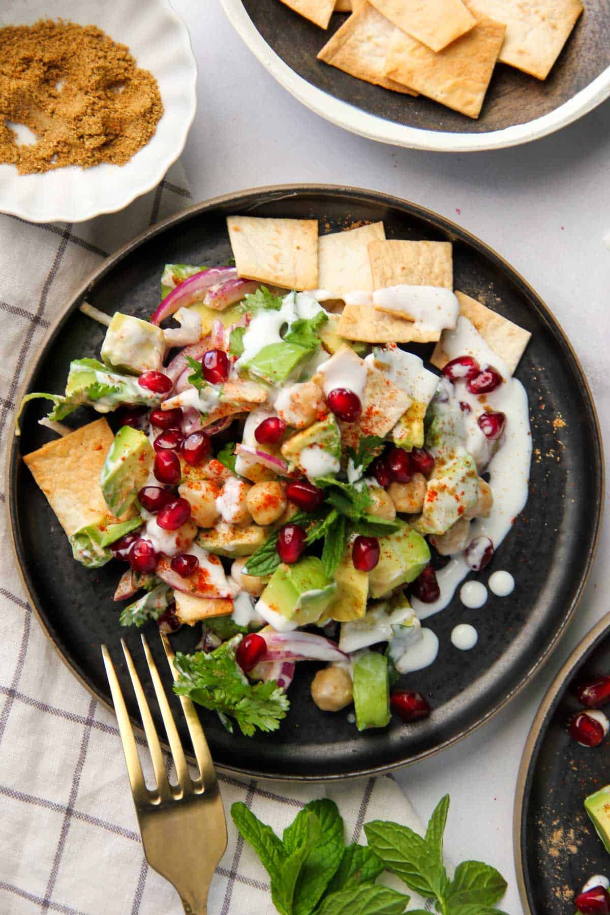 avocado chickpea salad garnished with pomegranates and mint