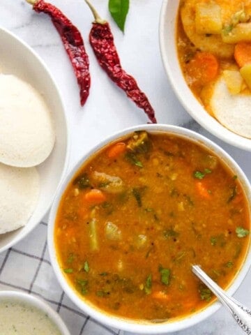 sambar served in a bowl alongside idli