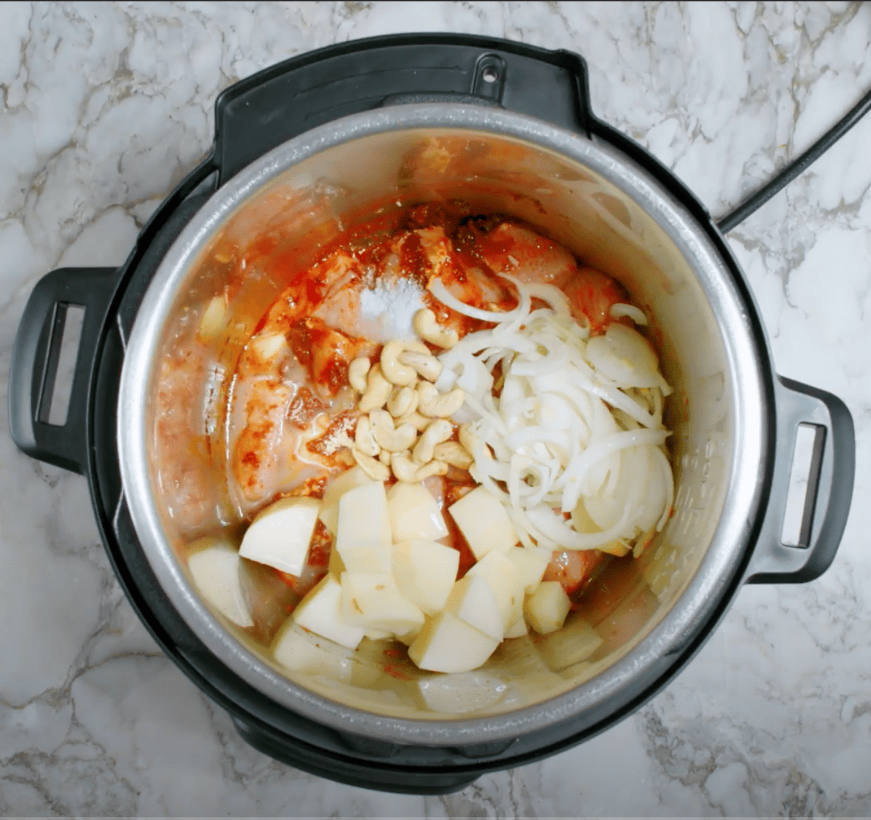 potatoes, cahsews, and onions added to Instant Pot. 