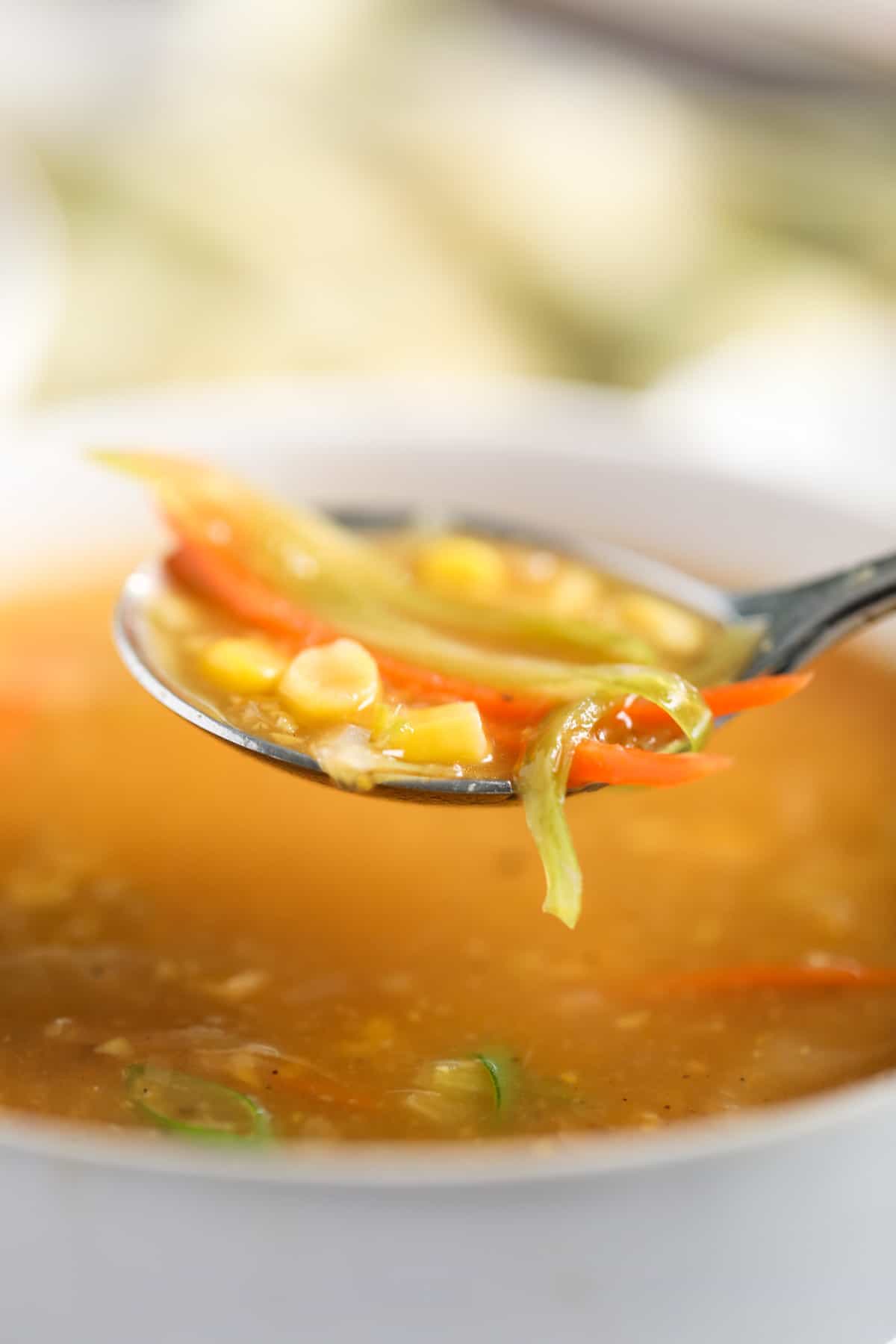 Sweet corn soup close up photo with soup in the spoon 