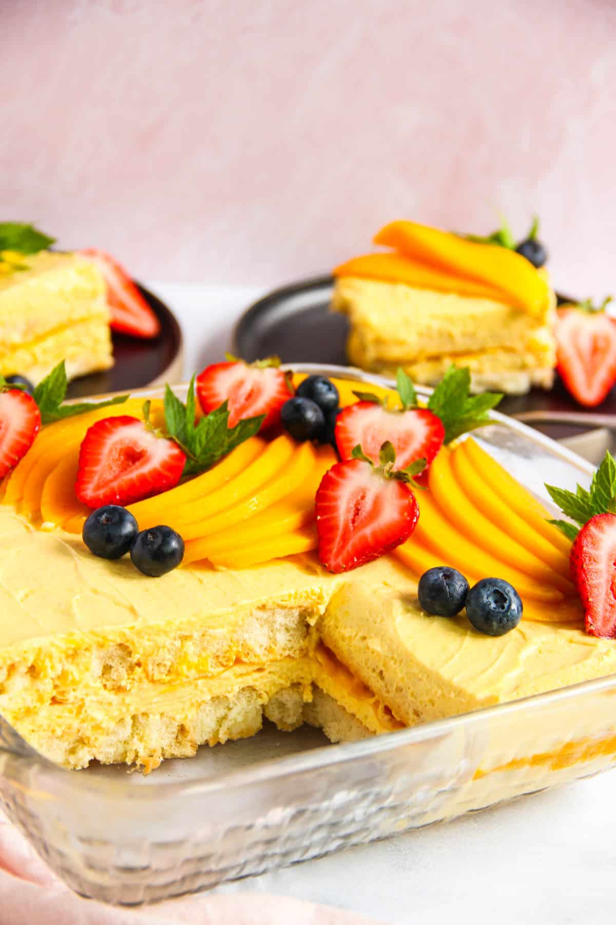 Mango Tiramisu cake garnished with fresh mangoes and berries