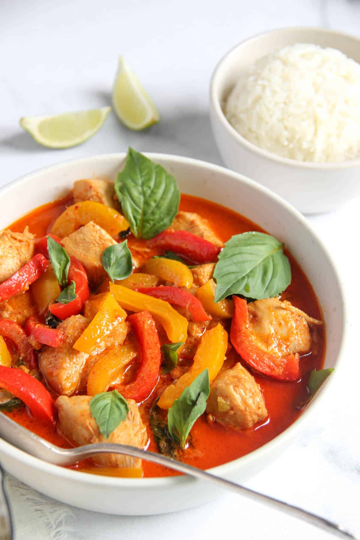 Panang curry with chicken garnished with Thai basil leaves 