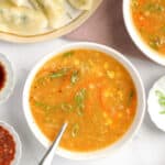 sweet corn soup in a white bowl garnished with scallions