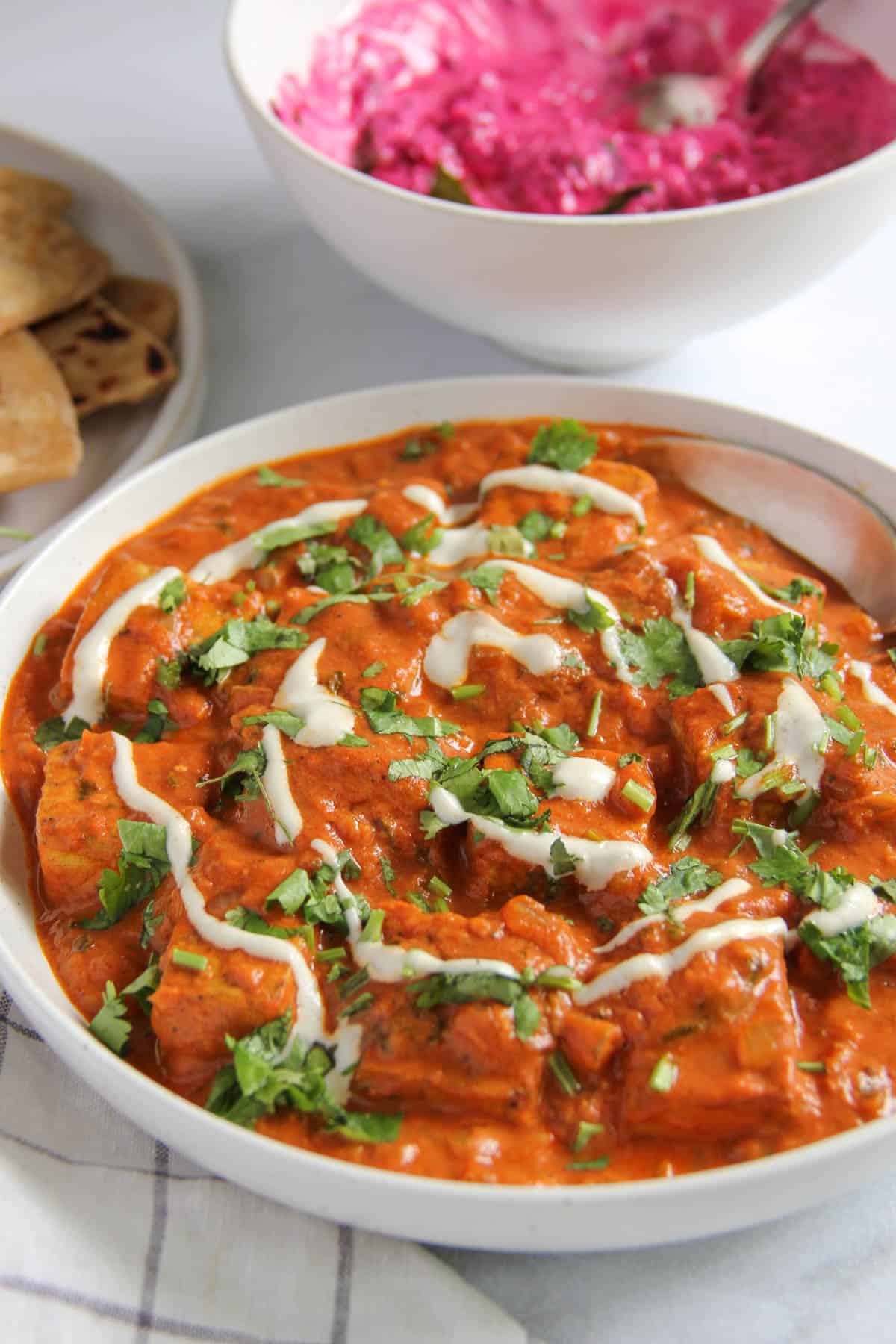 paneer makhani garnished with cilantro and cream