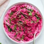 beet koshimbir in a white bowl garnished with cilantro and curry leaves