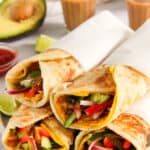 Kolkatta Egg Rolls wrapped in parchment paper and served alongside chai