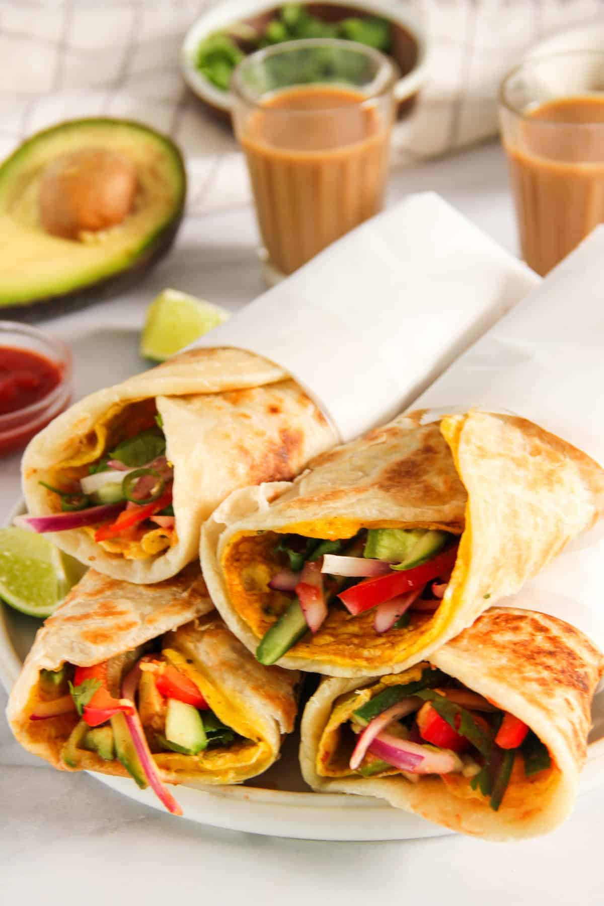 kolkata egg rolls wrapped in parchment paper and served alongside chai