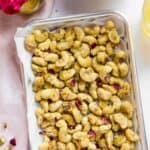 candied cashews in a parchment lined tray
