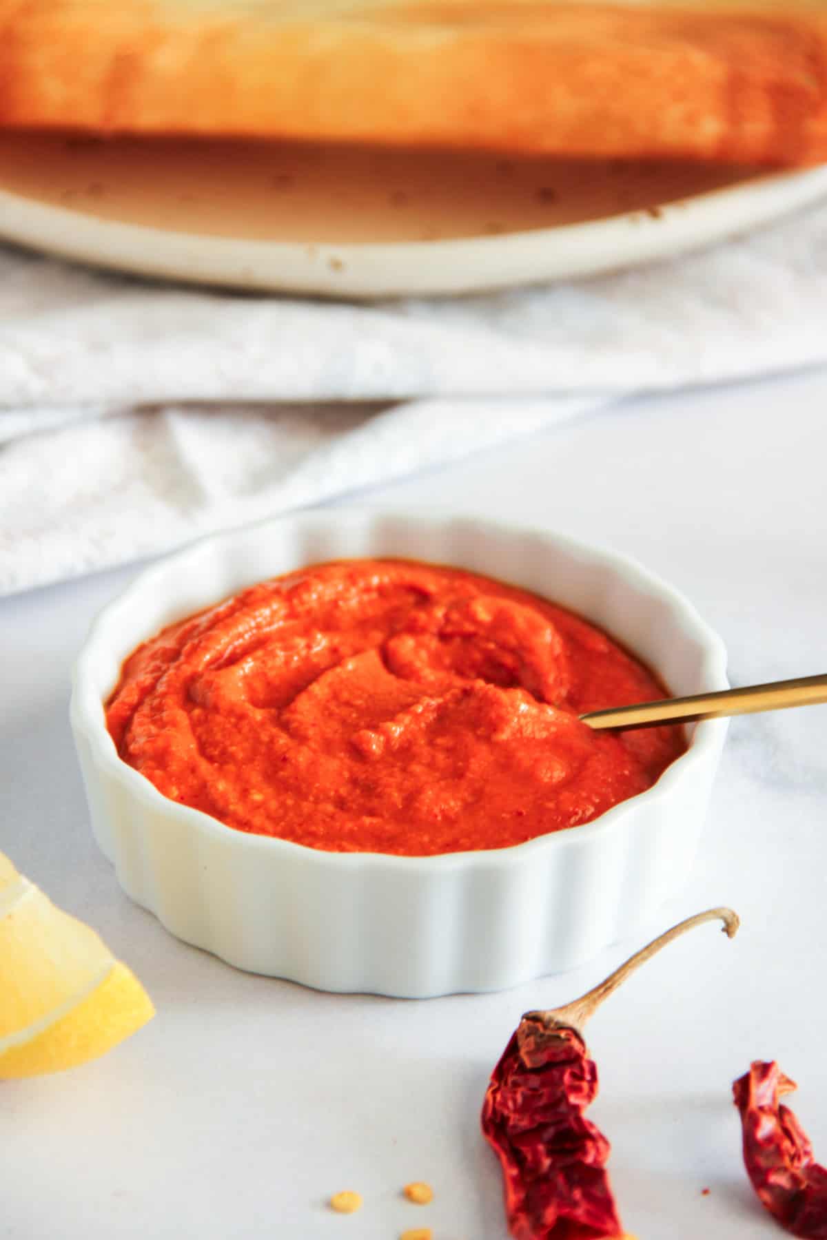 red dosa chutney in a white bowl 