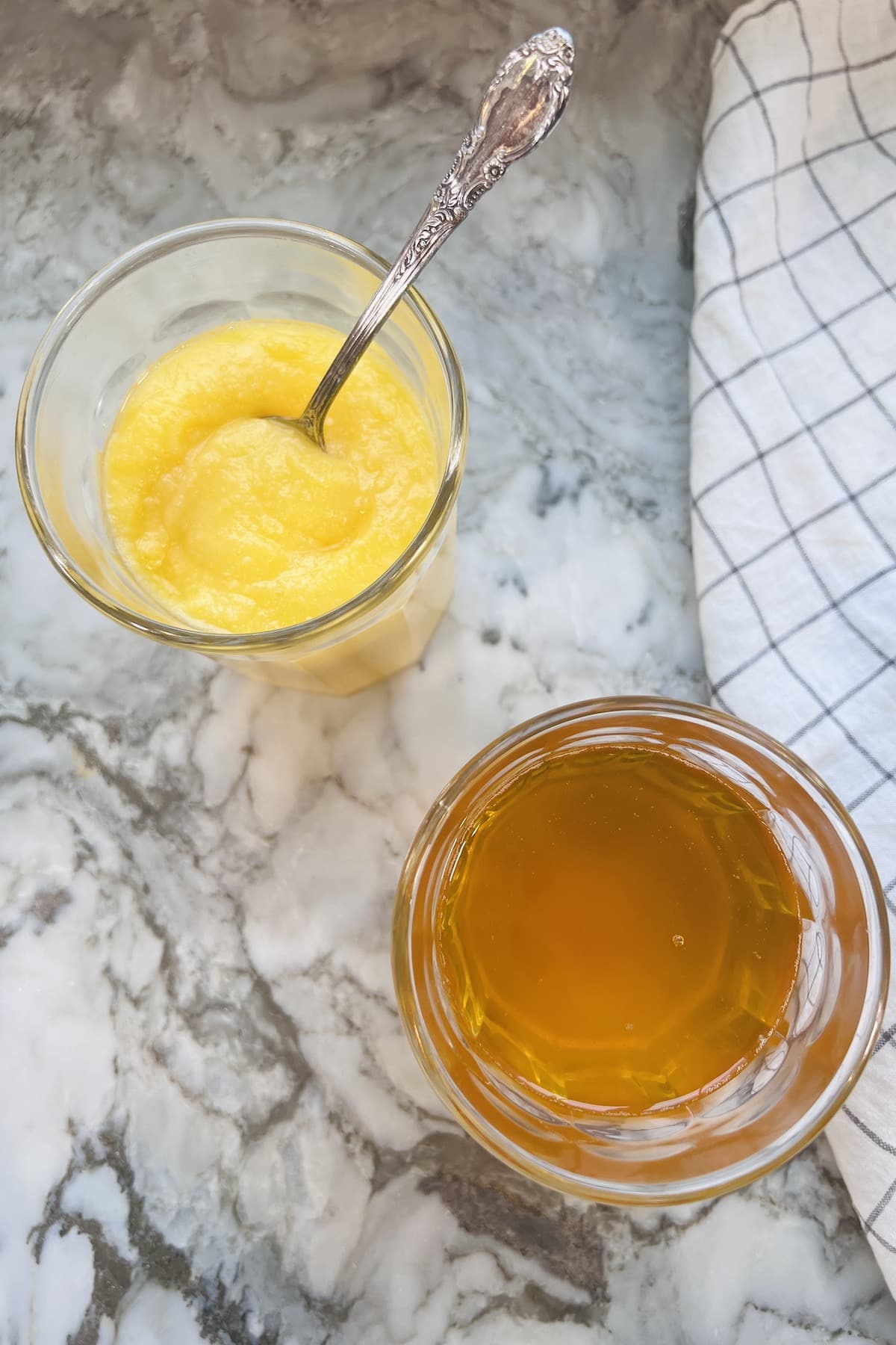 ghee in two glass jars one jar has melted ghee and second has thicker cold ghee 