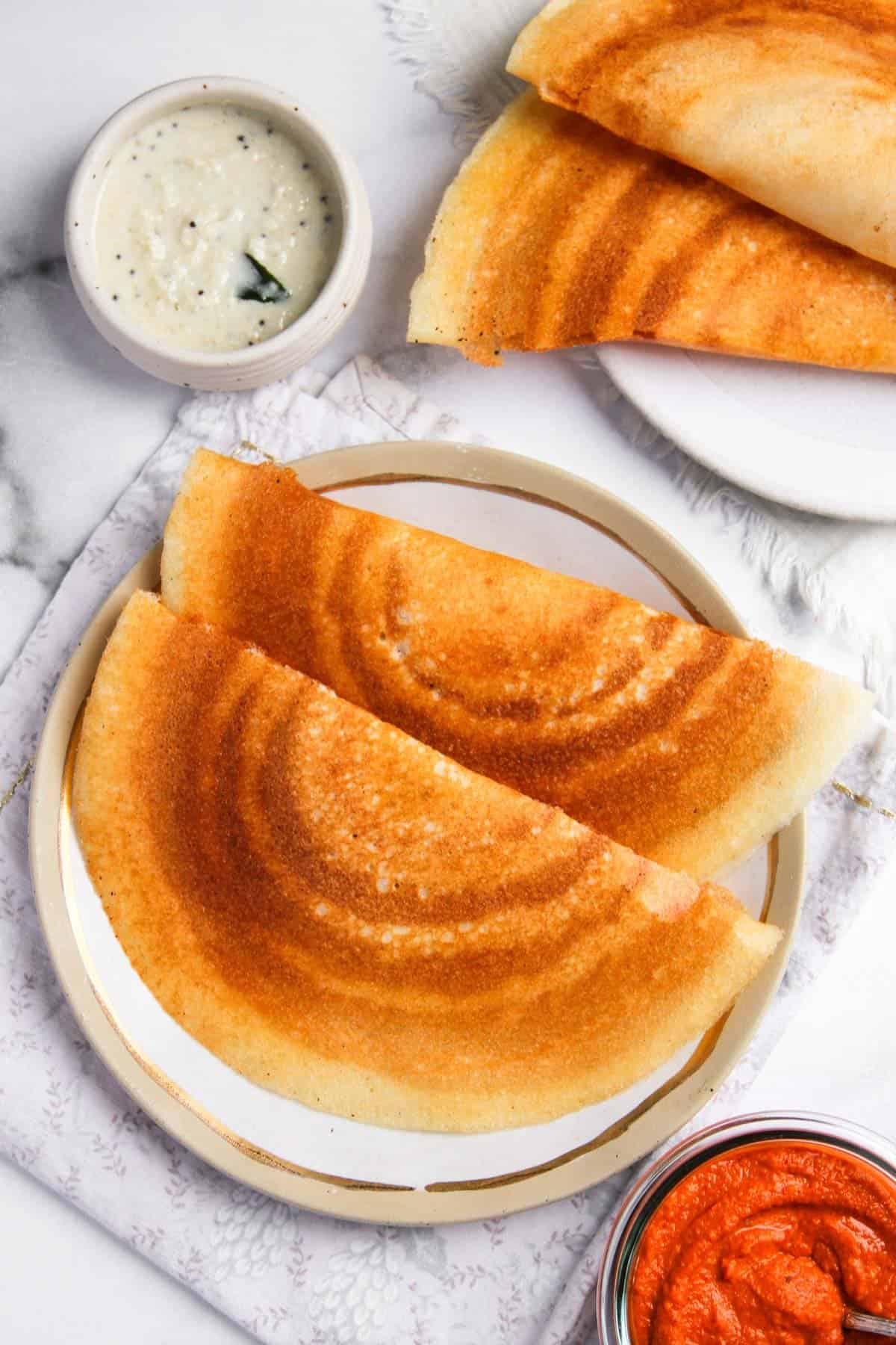 crispy dosa served with coconut chutney and red dosa chutney  