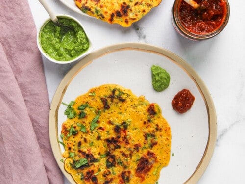 besan chilla served with cilantro mint chutney and pickles