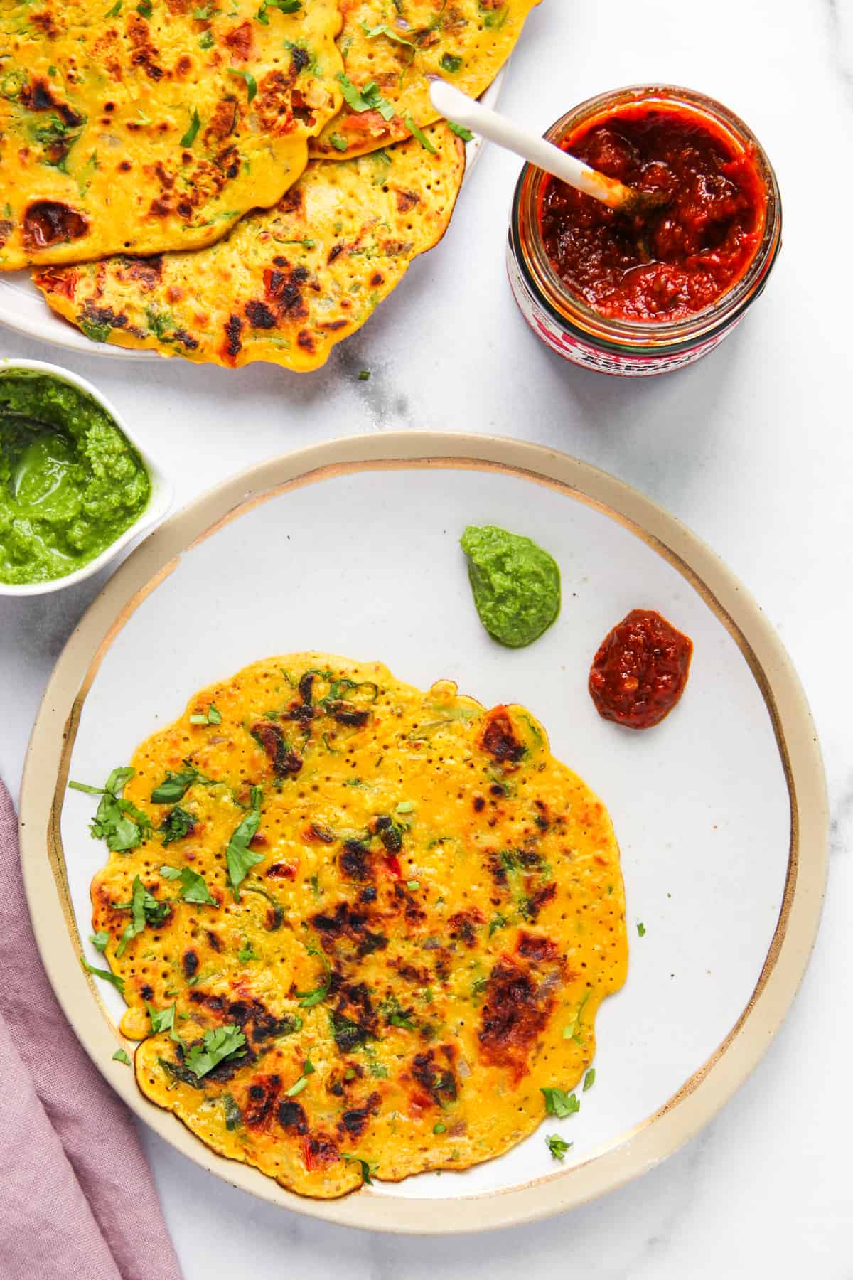 besan chilla served with cilantro mint chutney and pickles. 
