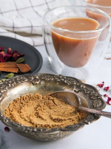chai masala next to whole spices and cup of chai