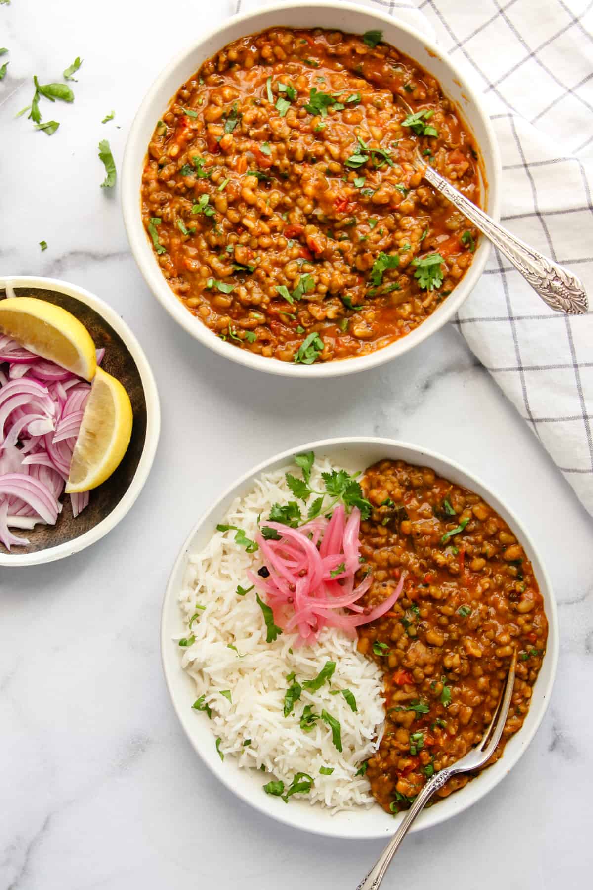 one bowl of green moong dal and another one one with moong dal, rice and pickles.