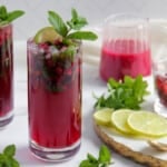 pomegranate mojito garnished with lime wedge and mint spring