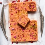 thandai kalakand in a silver platter garnished with dried rose petals and sliced pistachios.