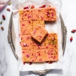 thandai kalakand in a silver platter garnished with dried rose petals and sliced pistachios.