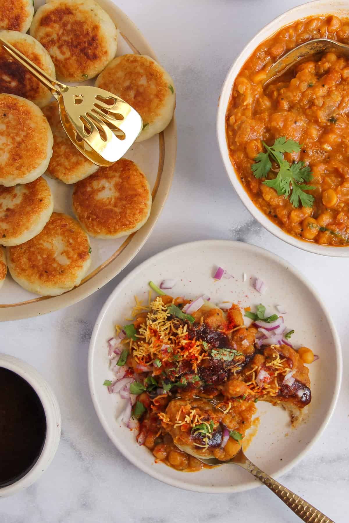 ragda patties garnished with onions, sev, tamarind chutney and cilantro 
