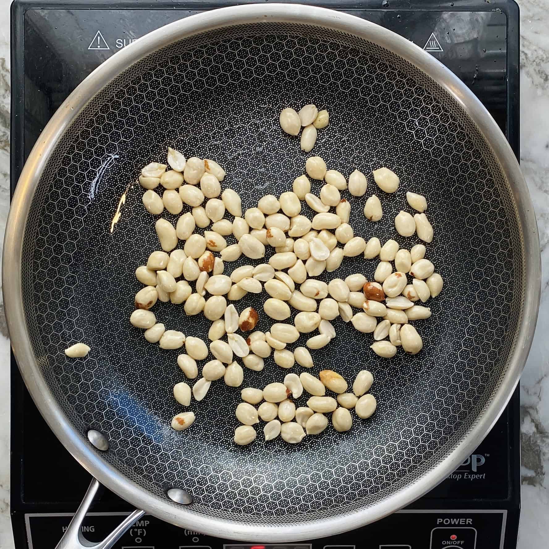 deskinned peanuts in a non stick pan.