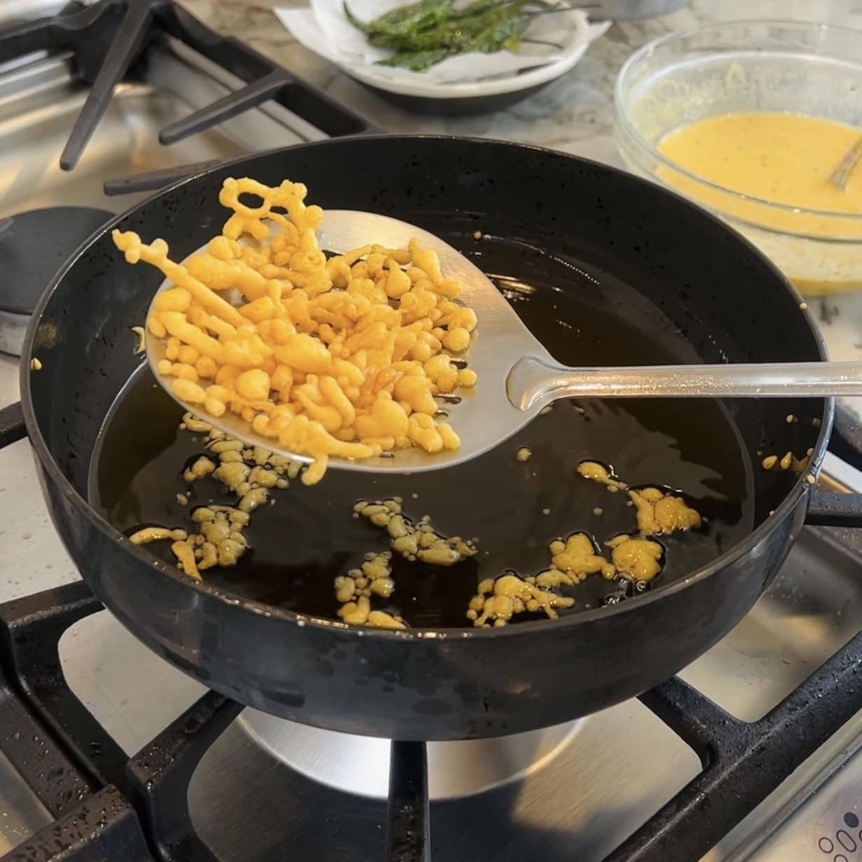 taking out fried besan chura using a slotted spoon 