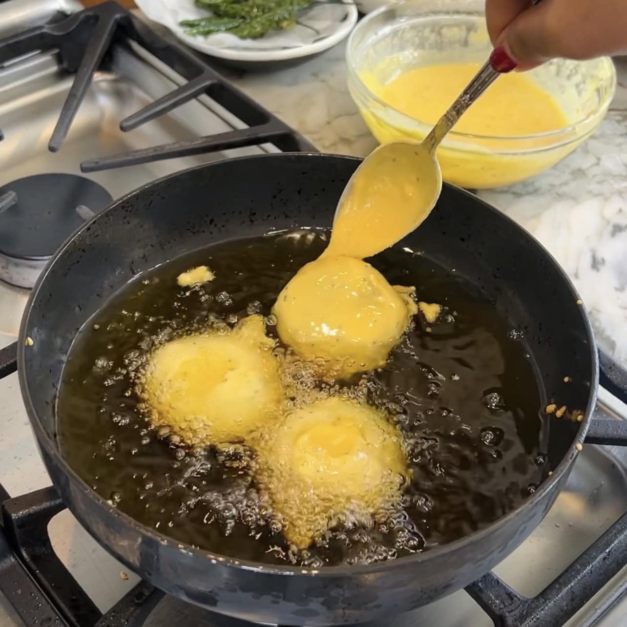 adding batata vada to hot oil 