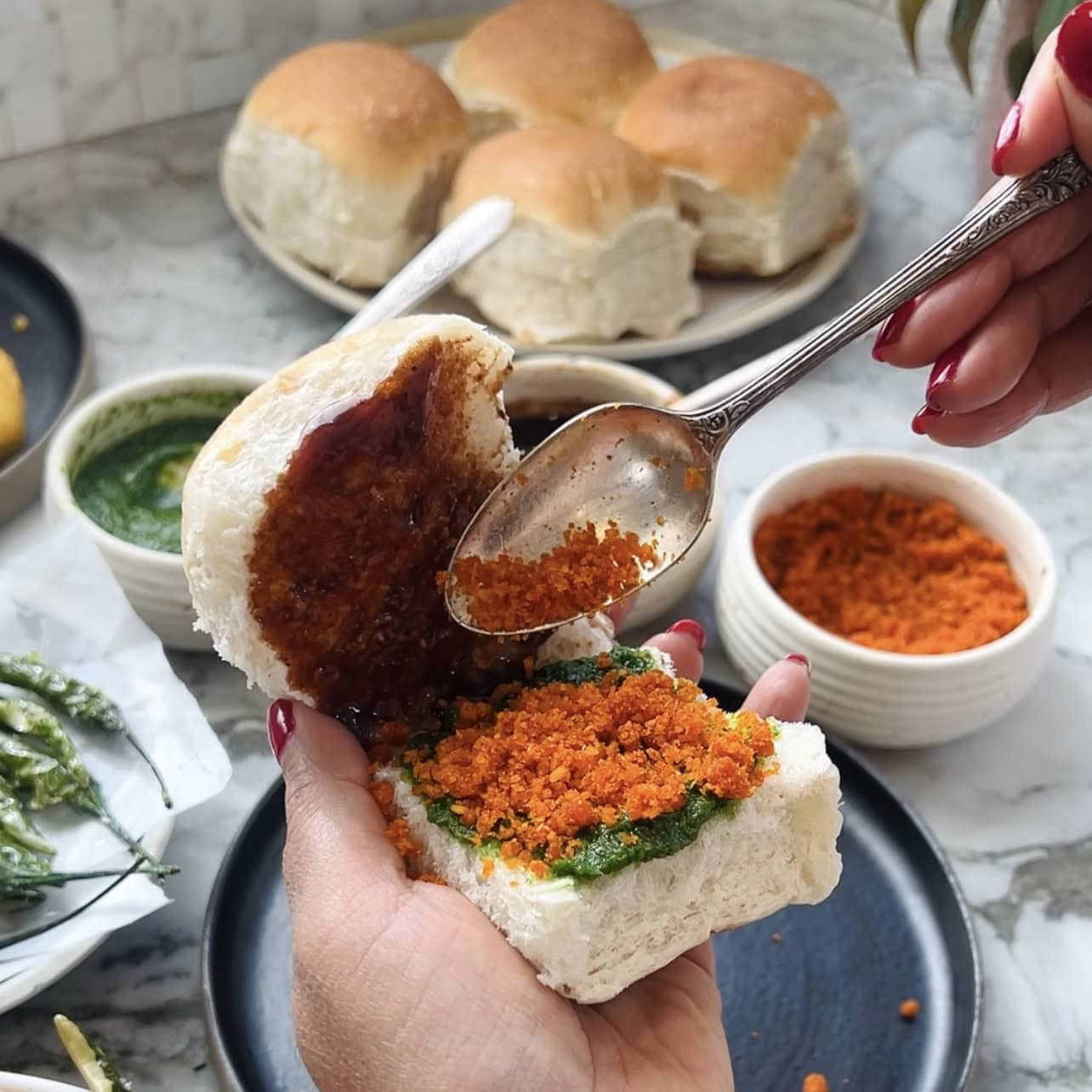 adding dry garlic chutney on pav
