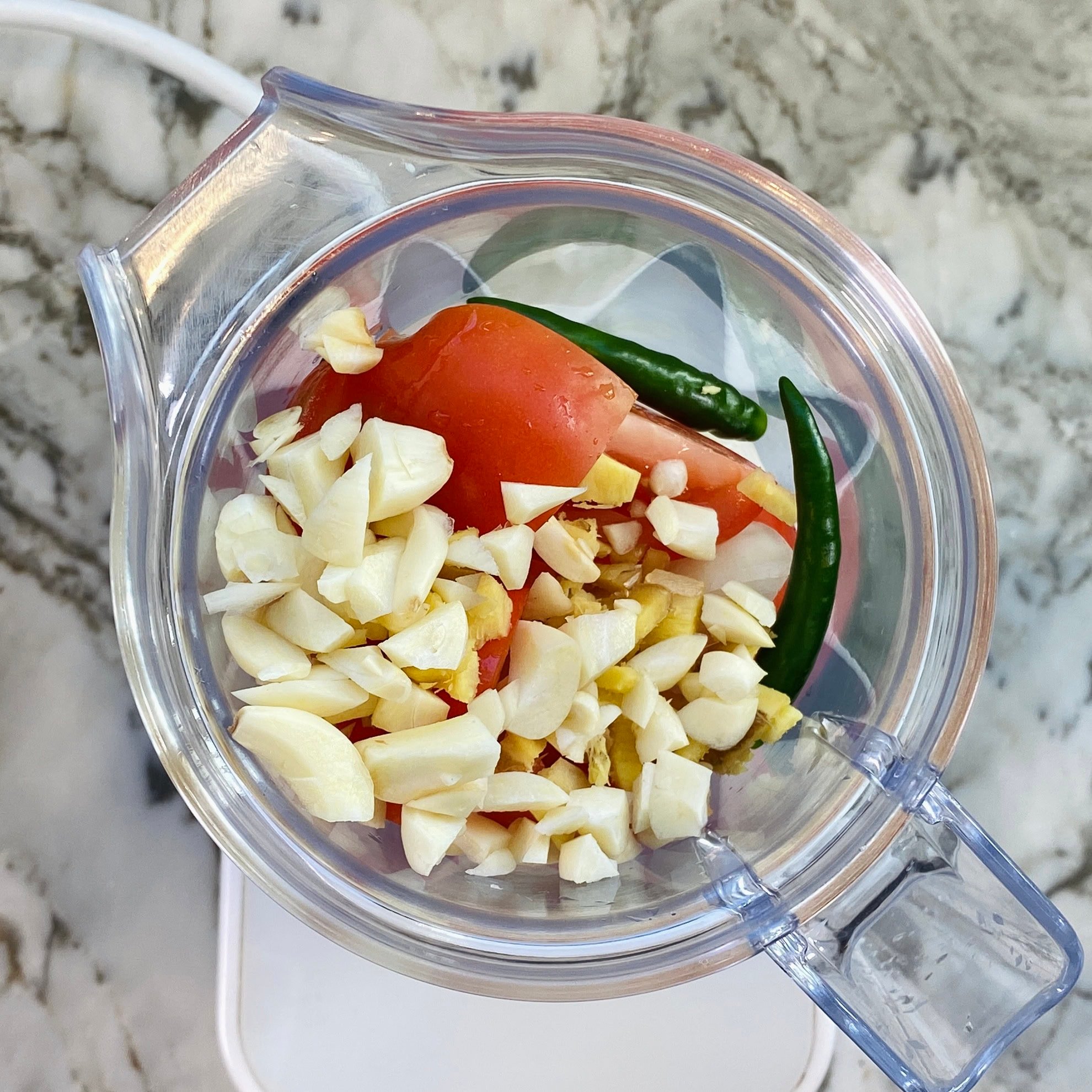 onion, ginger, garlic and green chilies in a blender 
