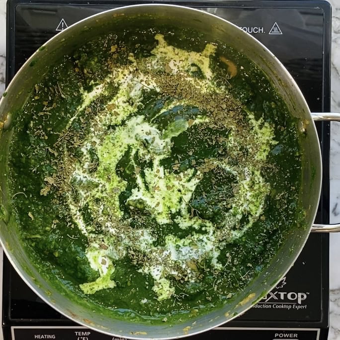 palak chicken garnished with cream and kasoori methi