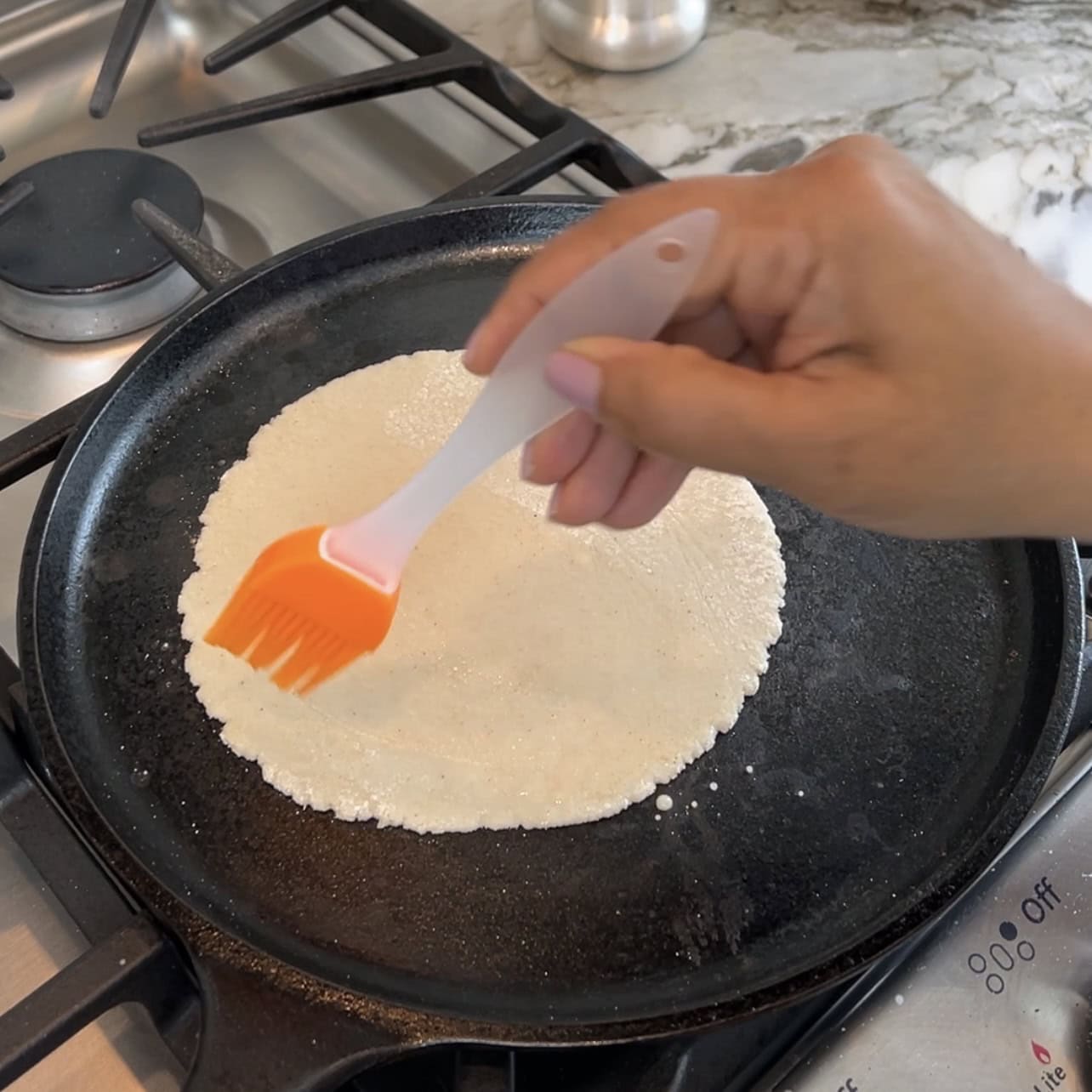 brushing water on jowar roti
