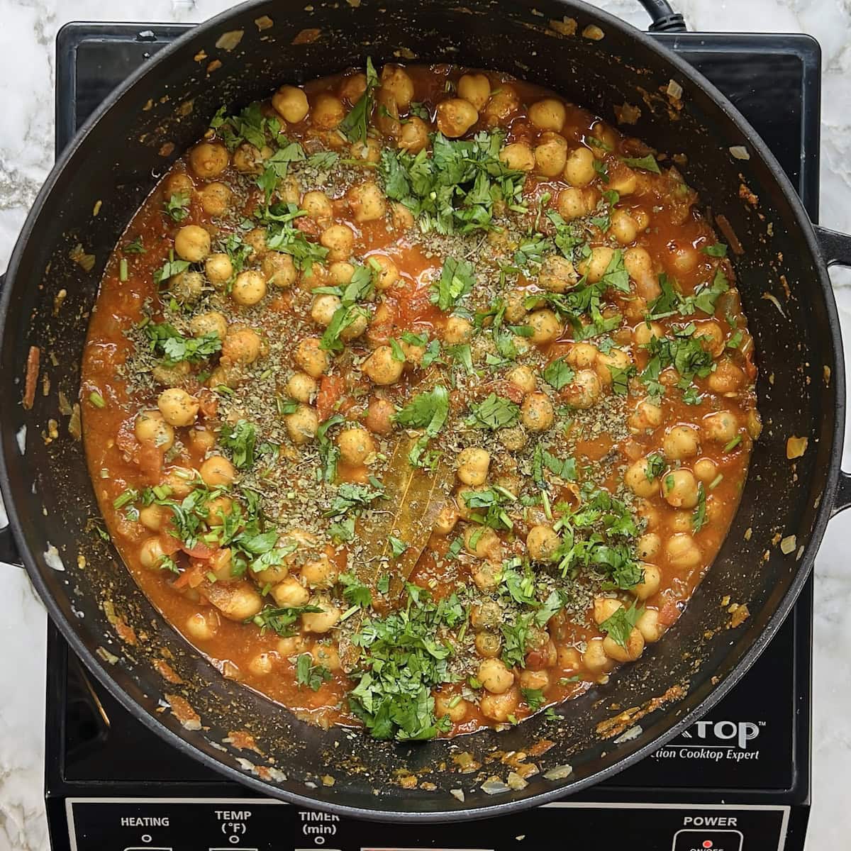 chana masala garnished with kasoori methi and cilantro 