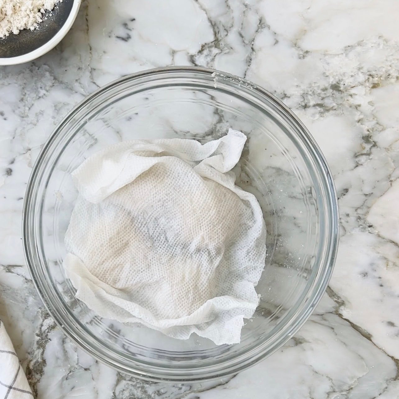 covered dough in a glass bowl