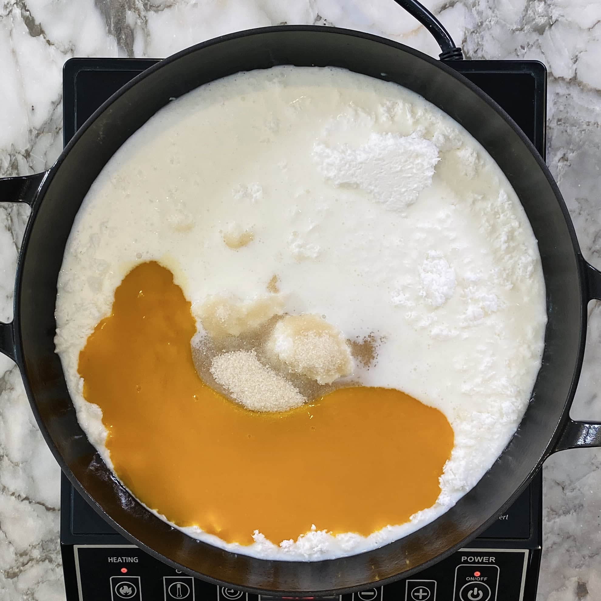 ingredients for mango coconut burfi in a enamled cast iron pan 