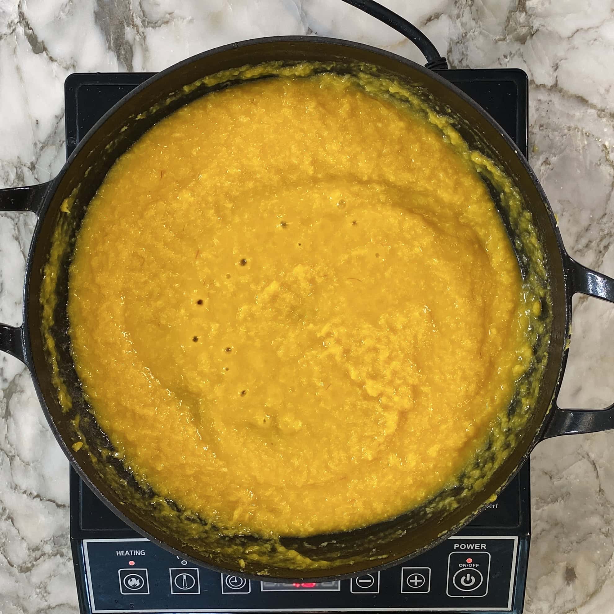 mango burfi thickening in a pan 