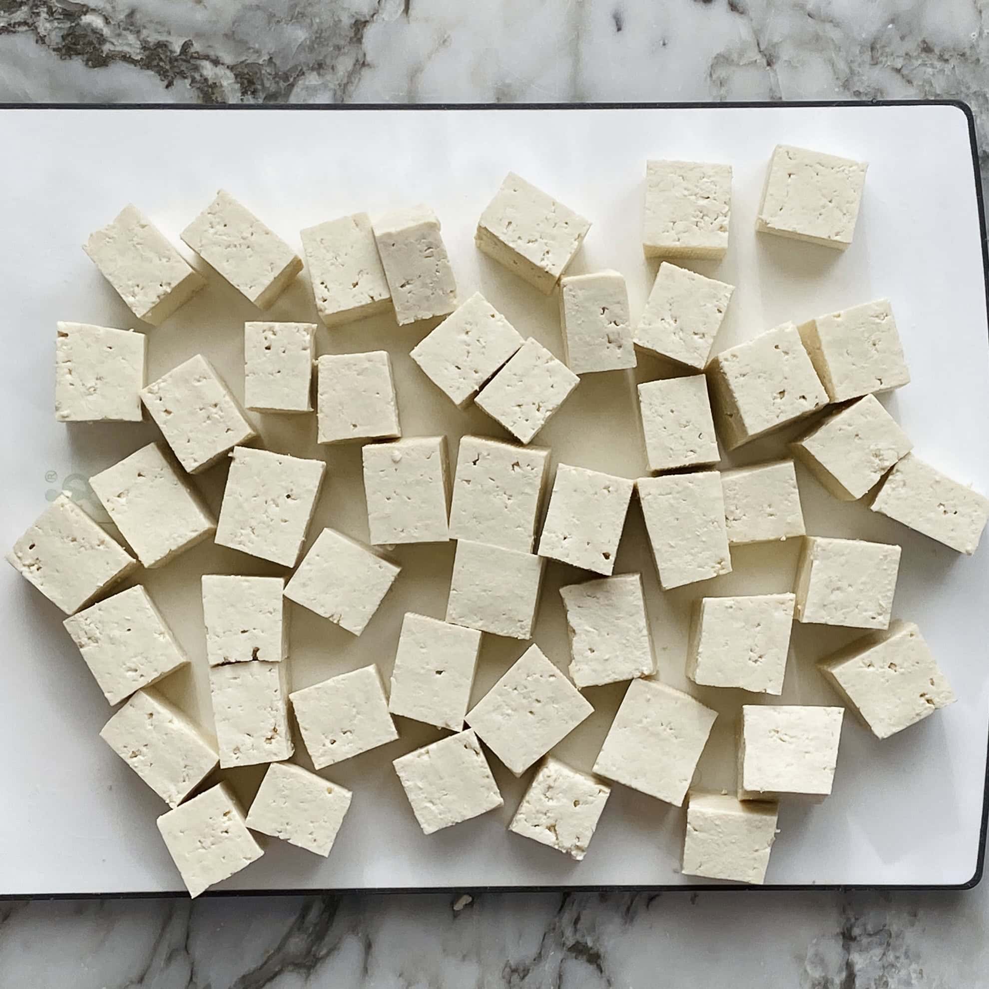 cubed tofu on a cuttong board