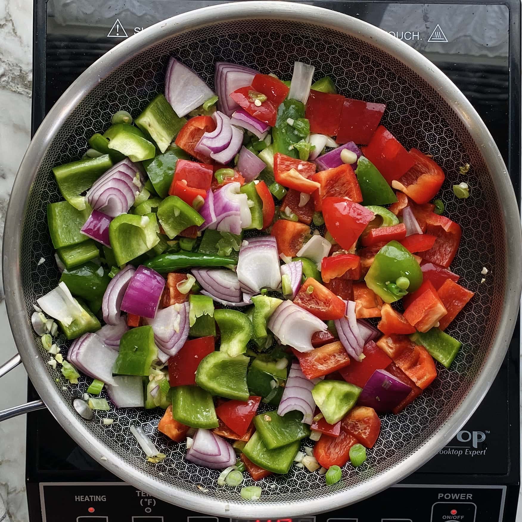 sauteeing onions and peppers in a pan 
