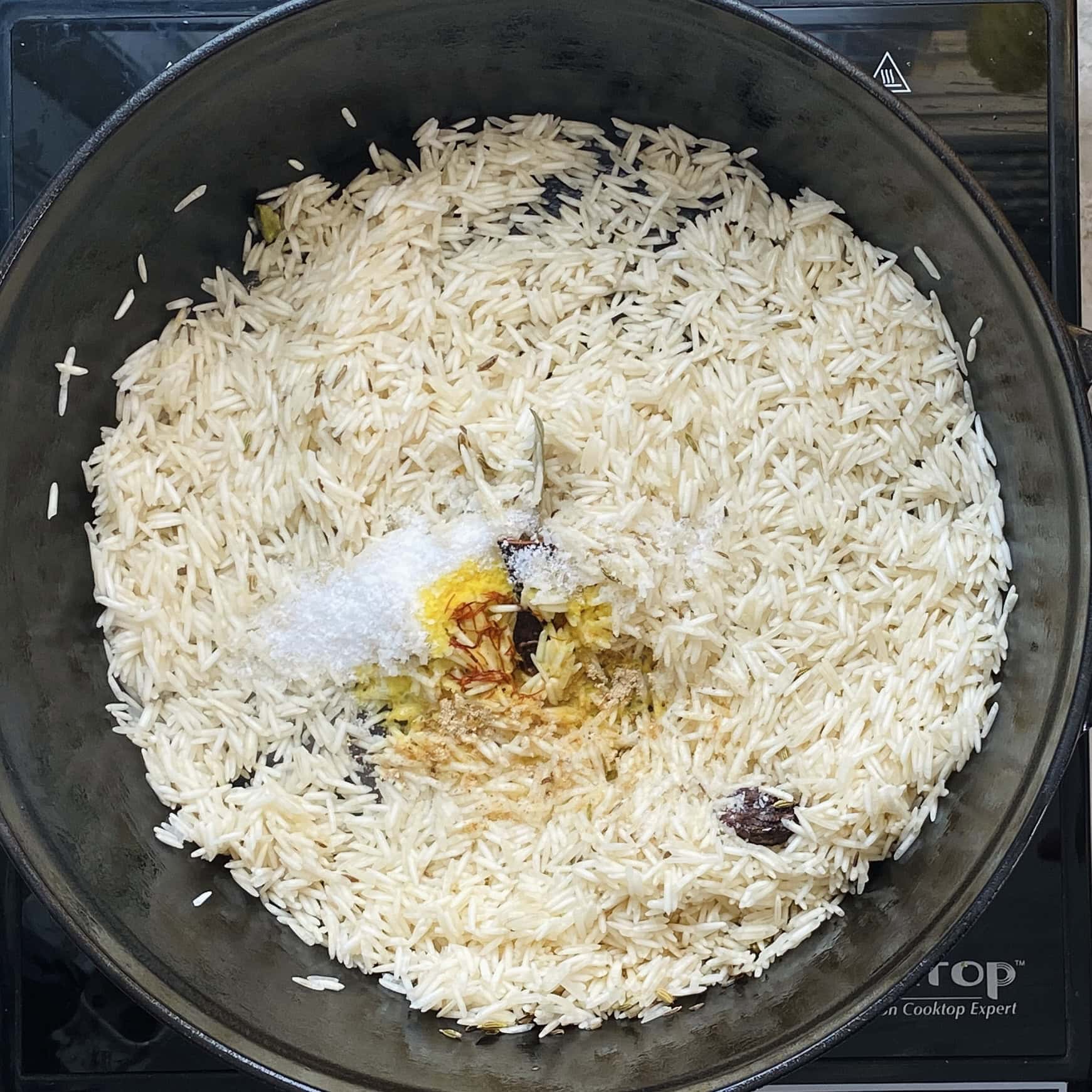 basmati rice, salt and saffron milk added to a pan 