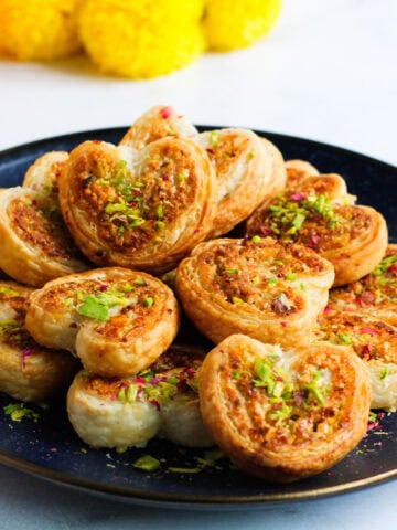 heart shaped gujiya bites garnished with pistachios.