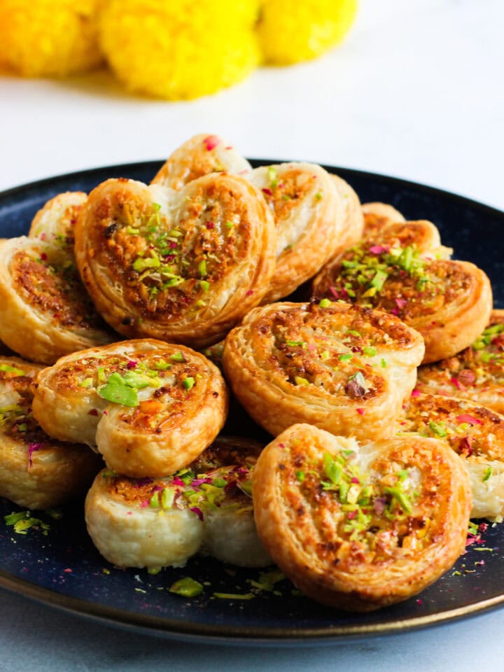 heart shaped gujiya bites garnished with pistachios.