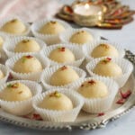 malai laddus garnished with pistachios and rose petals.