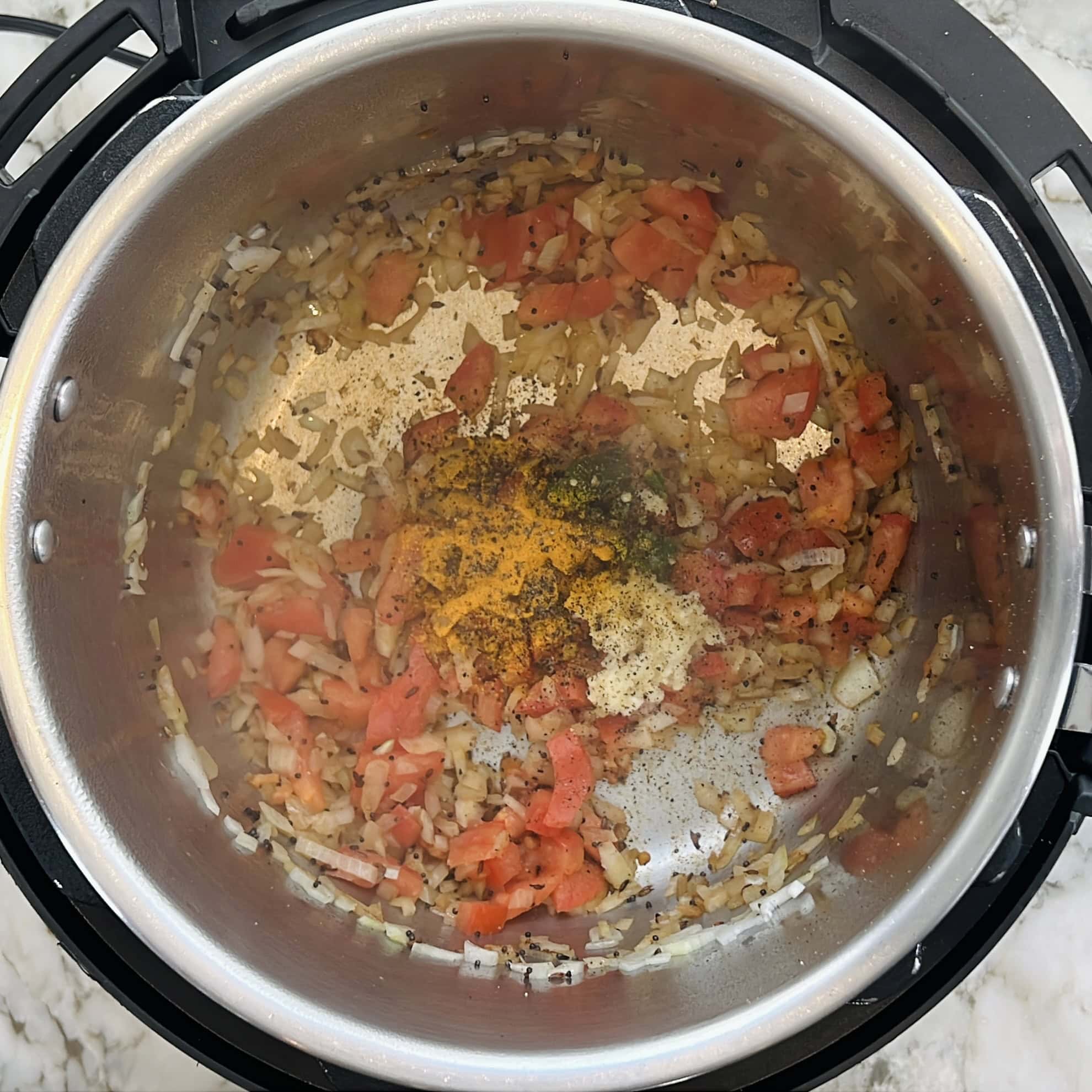 cooking onions tomatoes, garlic, chili and turmeric in the instant pot 