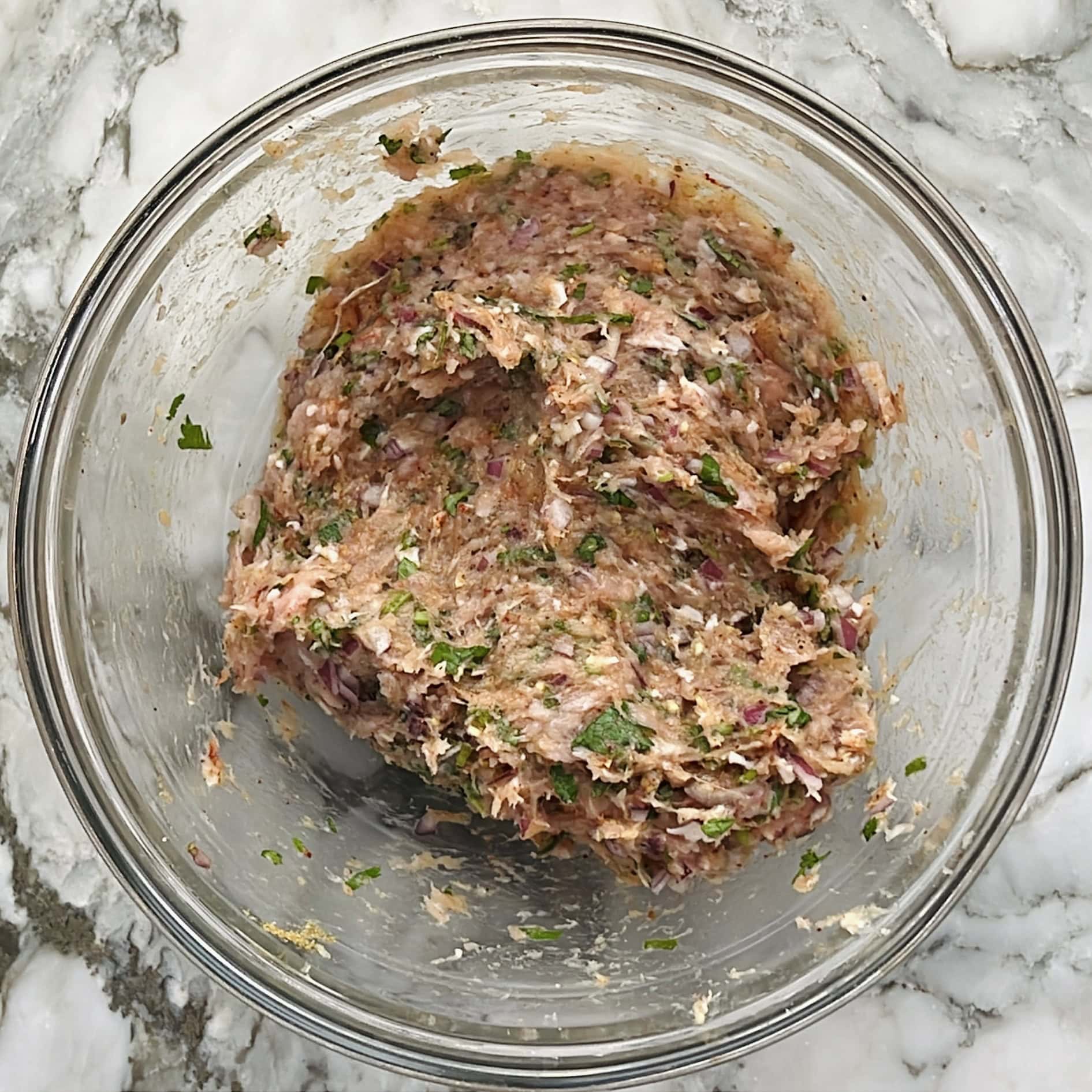 ground chicken mixed with spices in a bowl