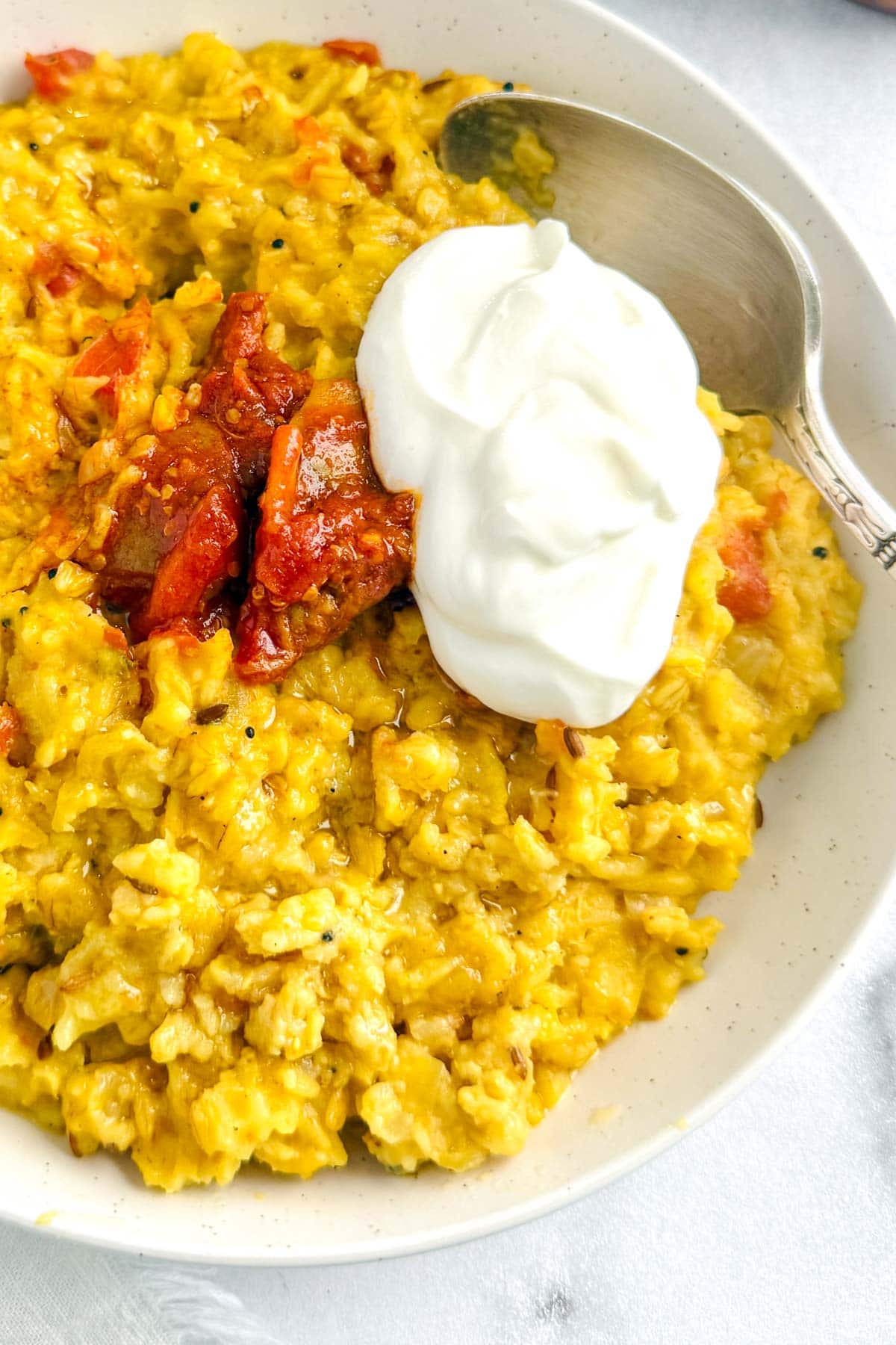 oats khichdi served with achaar and dollop of greek yogurt