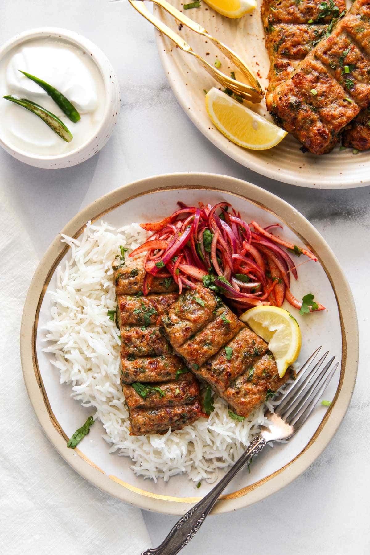 chicken seekh kebab served with basmati rice, spicy onions and lemon wedge 