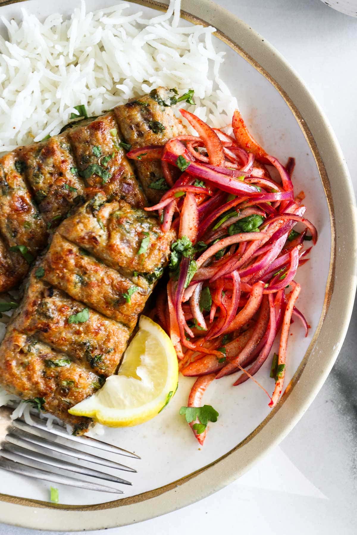 chicken seekh kebab served with laccha pyaaz over basmati rice 