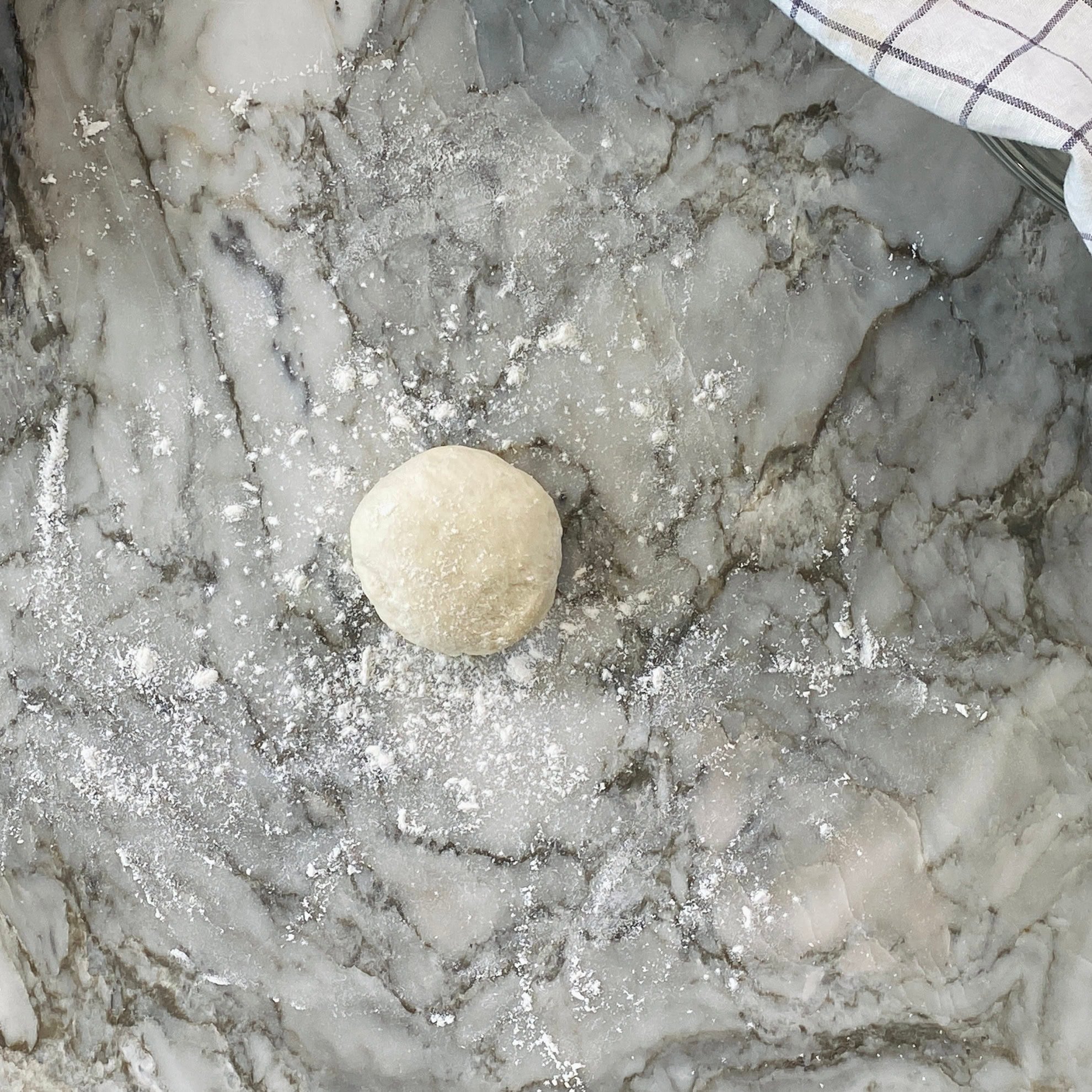 dough ball on flour dusted surface.