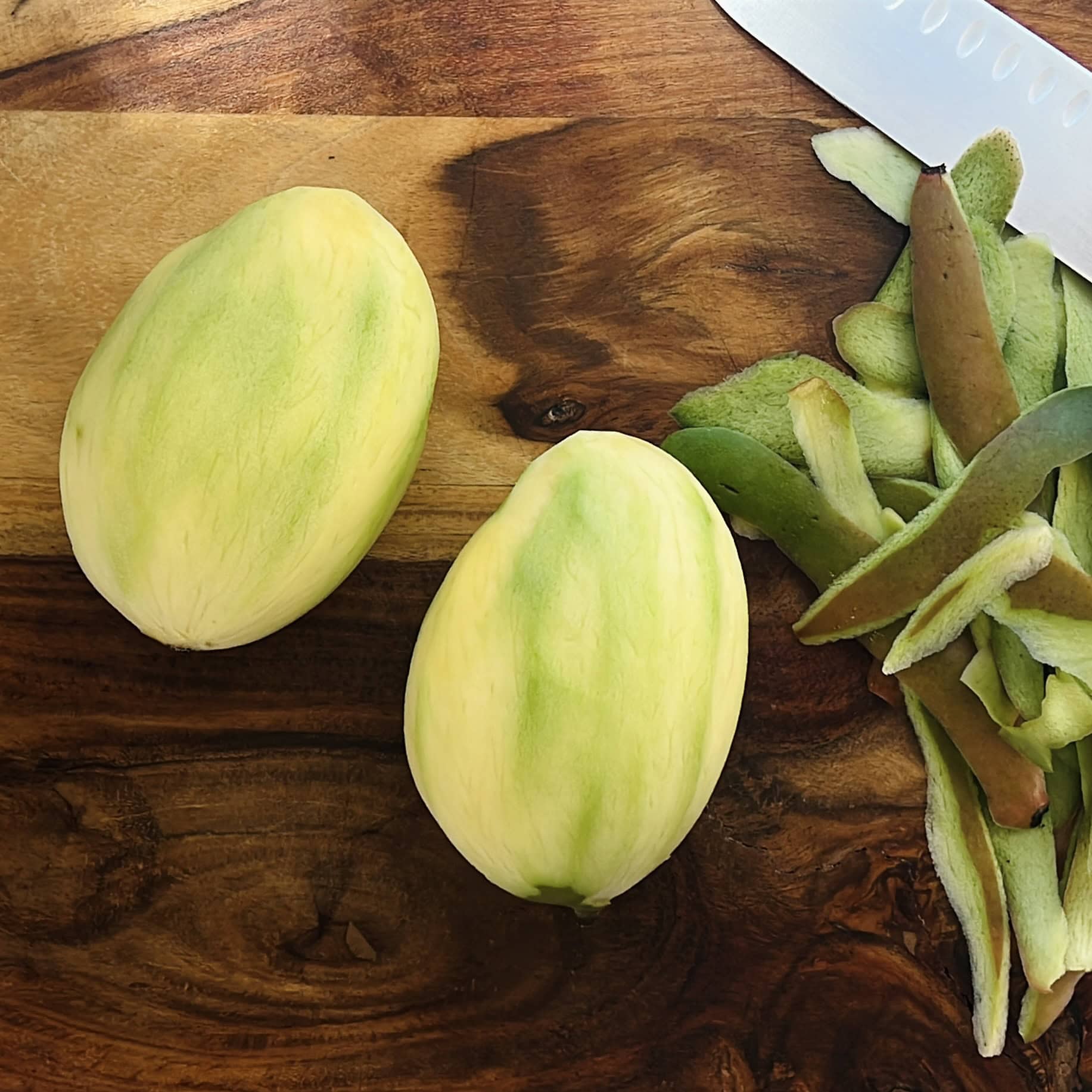 peeled mango on a cutting board.
